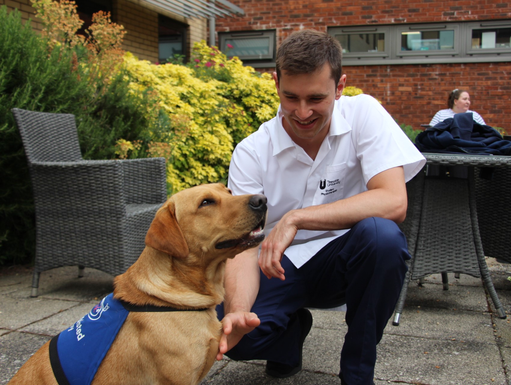 Student physiotherapist Miles Woolfenden spending time with therapy dog Kyro